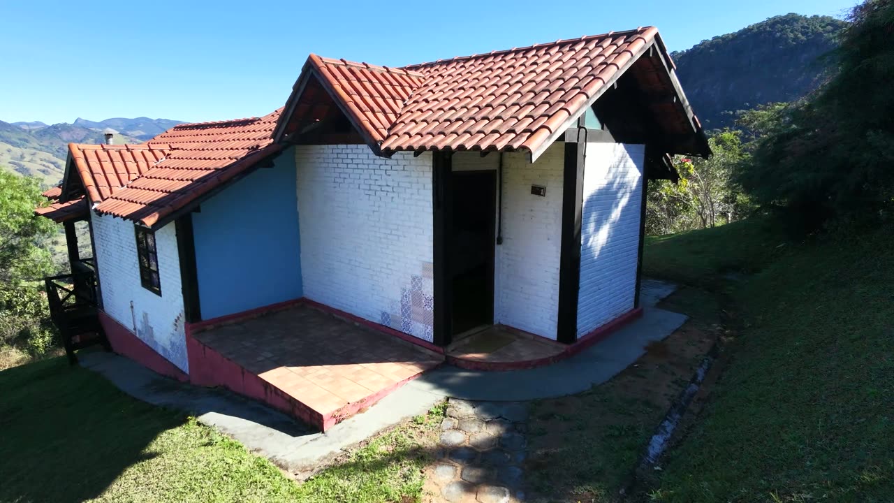 Interior do Chalé 1, com tijolo aparente e telhado de madeira.